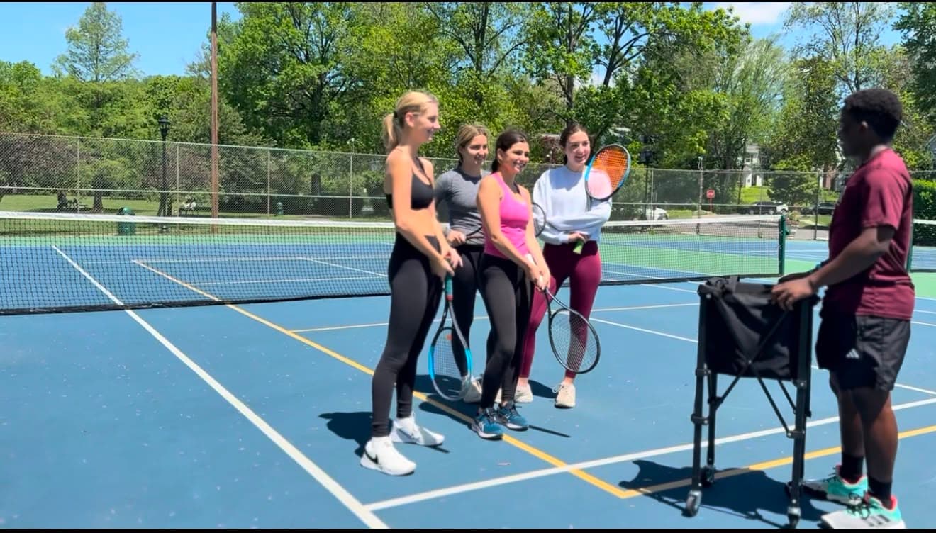 TD Tennis coach leading a group lesson on an outdoor court